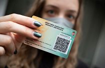 A Hungarian woman shows her government-issued COVID-19 immunity card in Budapest
