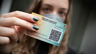 A Hungarian woman shows her government-issued COVID-19 immunity card in Budapest