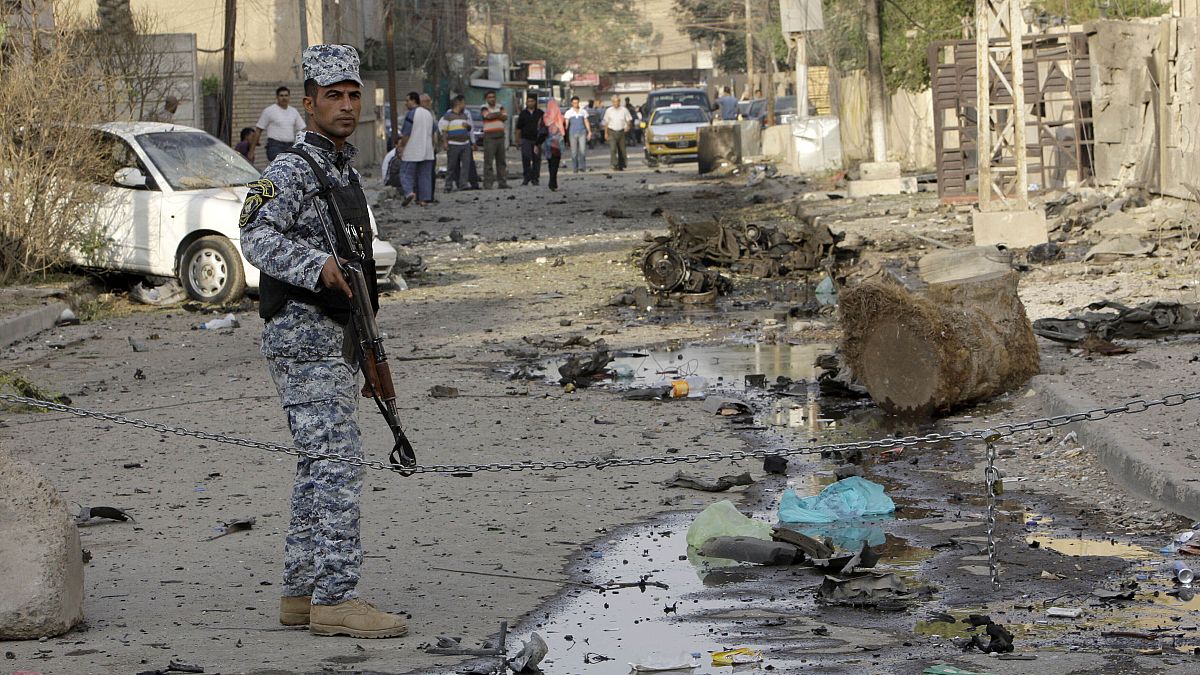 شرطي عراقي يحرس موقع انفجار سيارة مفخخة أمام كنيسة كاثوليكية في بغداد- العراق/ أرشيف. 