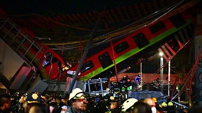 Rescue workers gather at the site of a metro train accident after an overpass for a metro partially collapsed in Mexico City on May 3, 2021. 