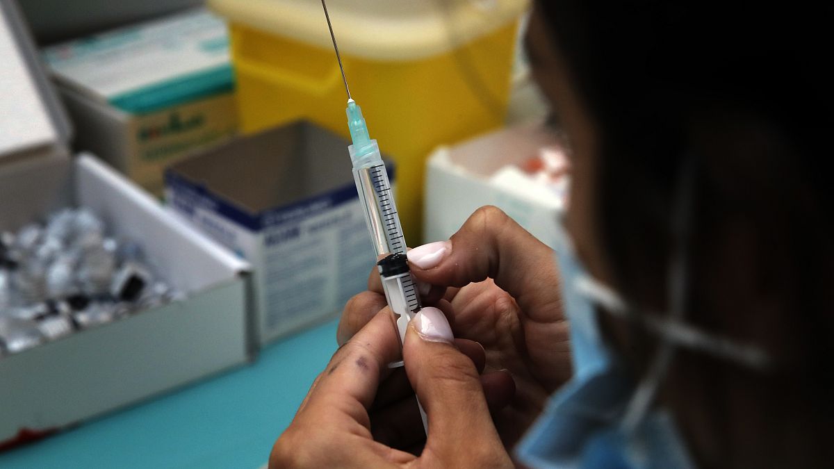 A medical staff prepares Pfizer's COVID-19 vaccine at a vaccination site in Paris