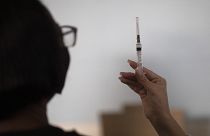 28 aprile 2021: a Rio de Janeiro, in Brasile, un'operatrice sanitaria mostra a una paziente una siringa con una dose del vaccino Sinovac
