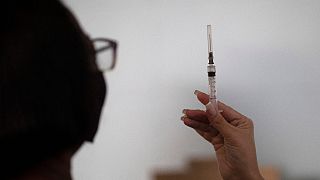 A healthcare worker looks at a syringe filled with the Sinovac COVID-19 vaccine in Sao Joao de Meriti, Rio de Janeiro state, Brazil on Wednesday, 28 April, 2021.