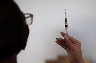 A healthcare worker looks at a syringe filled with the Sinovac COVID-19 vaccine in Sao Joao de Meriti, Rio de Janeiro state, Brazil on Wednesday, 28 April, 2021.