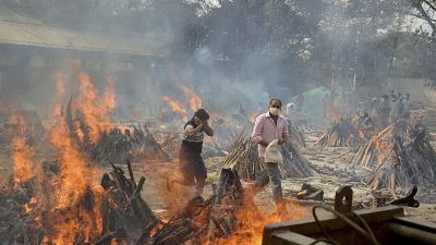 In this April 29, 2021, file photo, relatives react to heat emitting from the multiple funeral pyres of COVID-19 victims at a crematorium in the outskirts of New Delhi, India. In this April 29, 2021, file photo, relatives react to heat emitting from the multiple funeral pyres of COVID-19 victims at a crematorium in the outskirts of New Delhi, India.