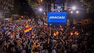 People gather outside the conservative Popular Party's regional headquarters in Madrid, Spain