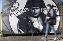 Eine Frau geht an einem Bild von Napoleon Bonaparte in Korsika vorbei
