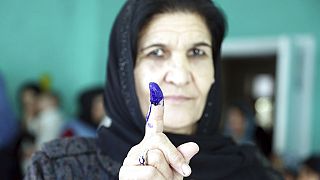 A 2018 photo depicts an Afghan woman showing her inked finger after casting her vote at a polling station during the Parliamentary elections in Kabul