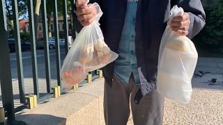 Homem mostra comida que recebeu numa igreja do centro do Porto