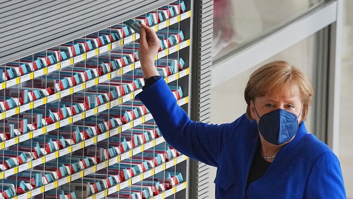 Angela Merkel nimmt ihre Wahlkarte für die Abstimmung im Bundestag