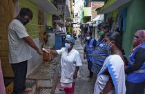 An Indian health worker checks body temperature of a man during a door-to-door survey being conducted as a precaution against COVID-19 in Hyderabad, India, May 6, 2021