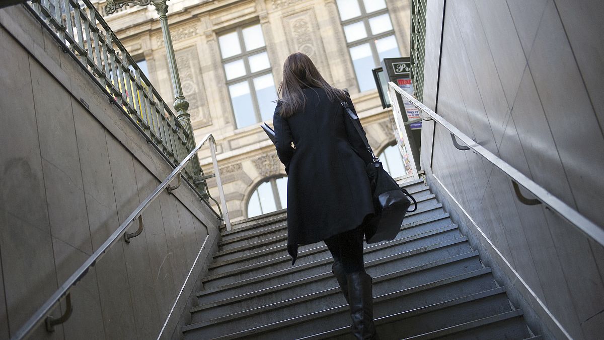 سيدة خارجة من إحدى محطات قطار المترو في باريس
