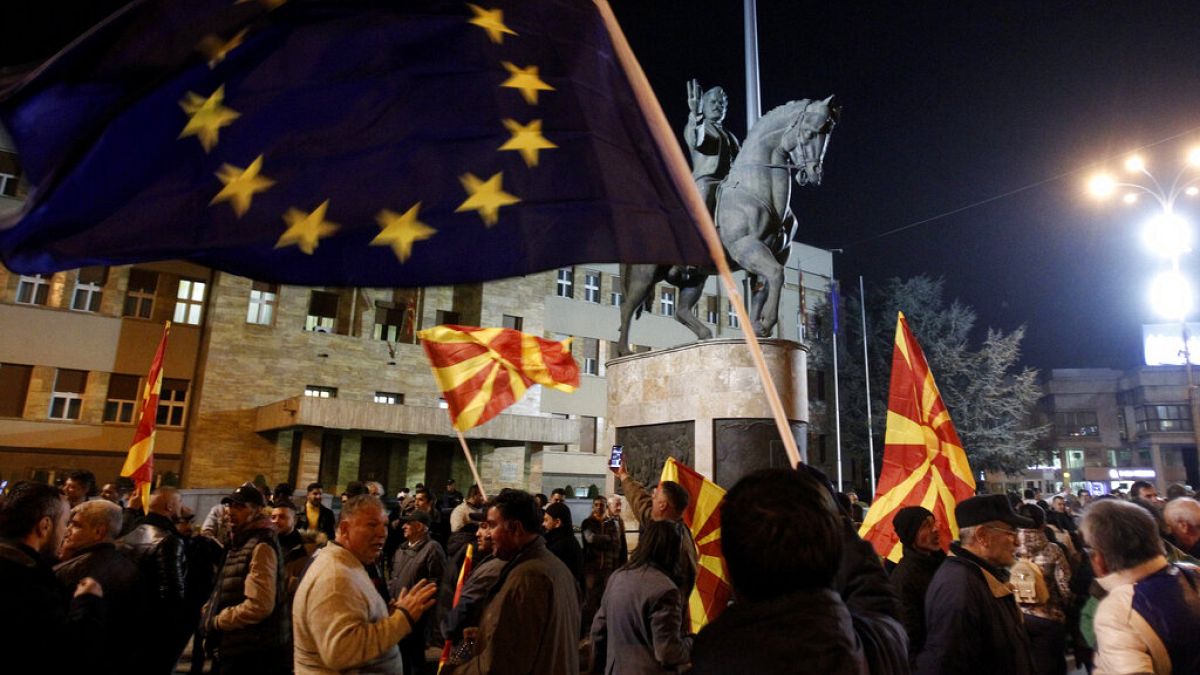 People waving national and EU flags gather for a rally in Skopje, North Macedonia