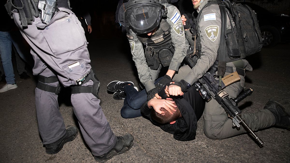 عناصر من الشرطة الإسرائيلية تعتقل شابا فلسطينيا وتطرحه أرضا خلال احتجاجات على تشريد عائلات مقدسية بحي الشيخ جراح. 06/05/2021