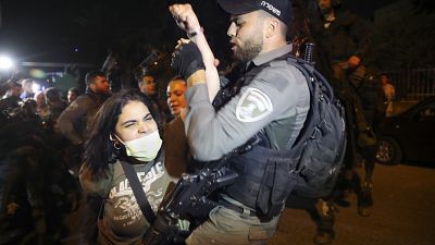 A Palestinian woman scuffles with Israeli border police officer during a protest against the planned evictions of Palestinian families in the Sheikh Jarrah
