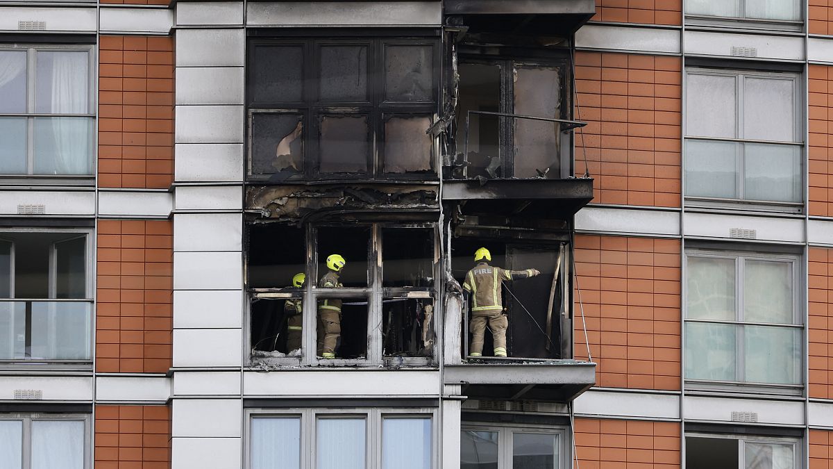 Firefighters are seen at work in a burned flat at the residential tower block in east London.
