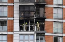 Firefighters are seen at work in a burned flat at the residential tower block in east London.