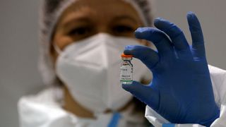 Una enfermera sostiene una dosis de la vacuna anticovid de Sinopharm