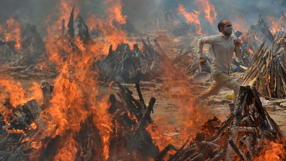 یک مرد از گرمای آتش جنازه سوزی در دهلی نو می‌گریزد/ ۲۹ آوریل