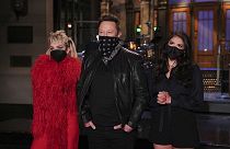 Miley Cyrus (sol), Elon Musk, ve Cecily Strong (sağ)
