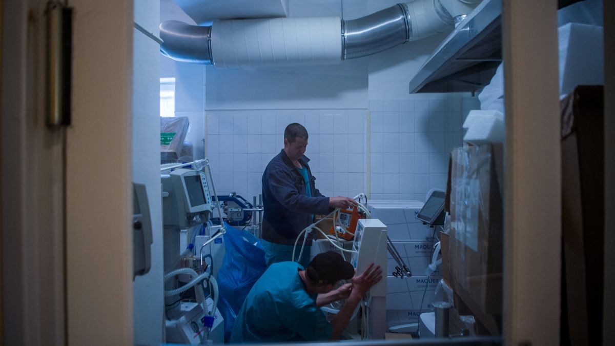 Műszerészek lélegeztető gépeket ellenőriznek egy raktárban 