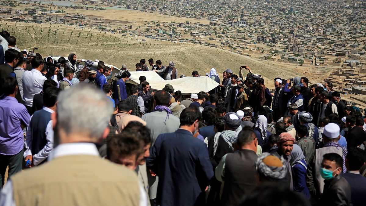 Afghan men bury a victim of the deadly bombings that killed more than 50 on Saturday