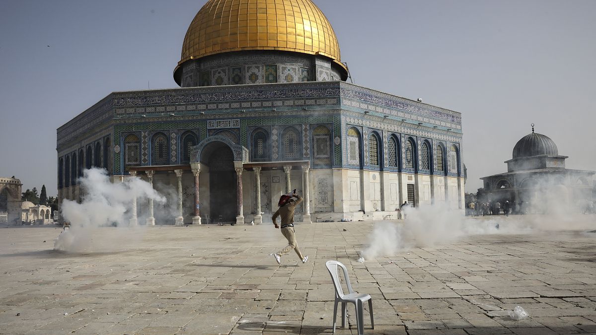 فلسطيني يهرب من الغاز المسيل للدموع خلال مواجهات مع قوات الأمن الإسرائيلية أمام مسجد قبة الصخرة في الحرم الأقصى