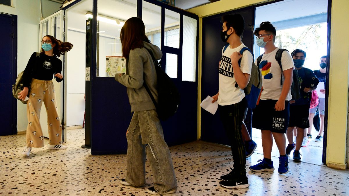 Students wearing face masks to help curb the spread of the coronavirus, wait to check their temperature at a junior high school in Athens, Monday, 10 May, 2021.