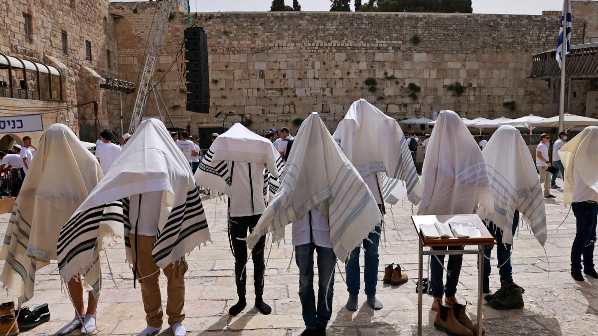 يهود يرتدون شالات الصلاة اليهودية التقليدية المعروفة باسم تاليت بالقرب من الحائط الغربي، أقدس موقع يُسمح لليهود بالصلاة فيه في البلدة القديمة في القدس