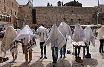 يهود يرتدون شالات الصلاة اليهودية التقليدية المعروفة باسم تاليت بالقرب من الحائط الغربي، أقدس موقع يُسمح لليهود بالصلاة فيه في البلدة القديمة في القدس