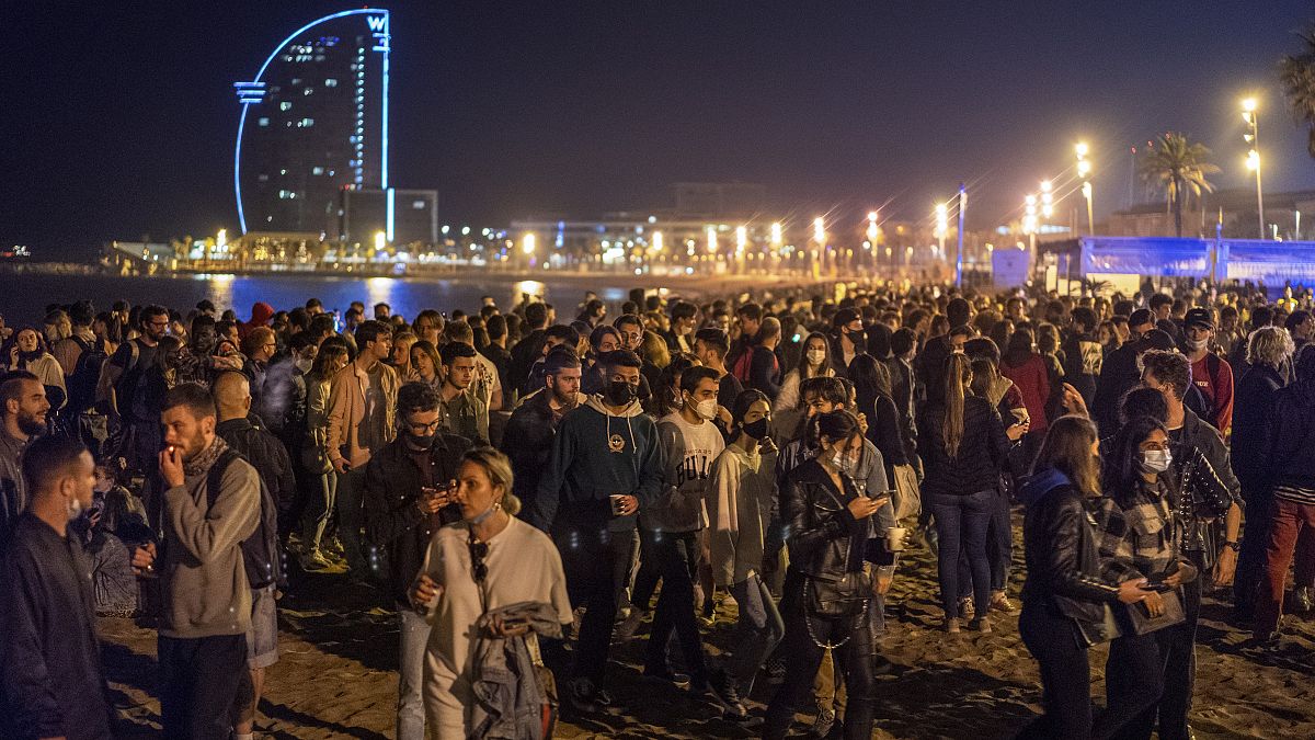 People crowded on the beach in Barcelona, Spain, Sunday, May 9, 2021. Barcelona residents were euphoric as the clock stroke midnight, ending a six-month state of emergency.