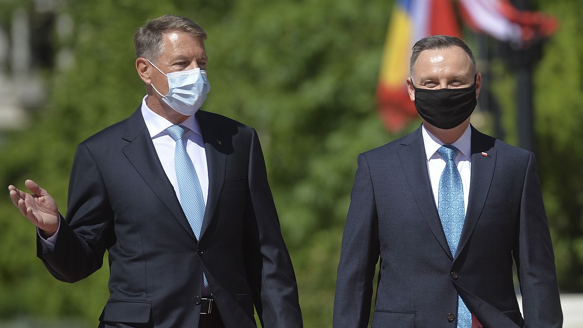 Polish President Andrzej Duda, right, reviews the honor guard with Romanian President Klaus Iohannis during the welcoming ceremony at the Cotroceni presidential palace.