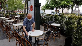 Un employé d'un café parisien préparant la terrasse du café, le 11 mai 2021, en vue de la reprise de l'activité prévue le 19 mai prochain