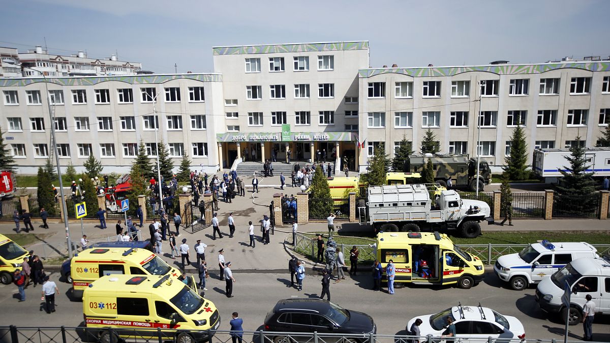 Ambulances and police cars and a truck are parked at a school after a shooting in Kazan, Russia, Tuesday, May 11, 2021. 