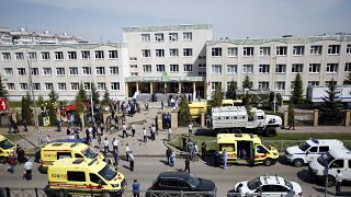 Ambulances and police cars and a truck are parked at a school after a shooting in Kazan, Russia, Tuesday, May 11, 2021. 