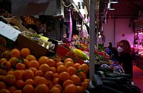 A woman checks fruit and vegetables at the Cebada market in Madrid
