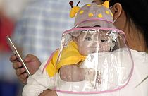 Baby mit Gesichtsschutz auf dem Flughafen in Wuhan, China, 23. Mai 2020