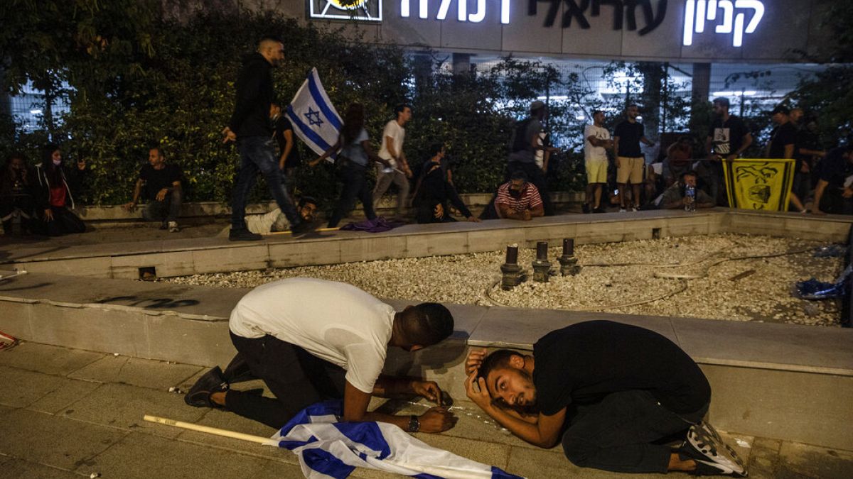 Des manifestants juifs s'abritent alors que des roquettes ont été tirées depuis Gaza, à Ramla, Israël, le 11 mai 2021
