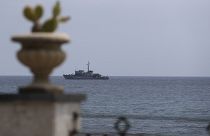 An Italian navy ship patrols the waters in front of the Sicilian town of Taormina in the Mediterranean Sea.