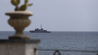 An Italian navy ship patrols the waters in front of the Sicilian town of Taormina in the Mediterranean Sea.