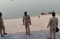 This frame grab from video provided by KK Productions shows police officials stand guard at the banks of the river where several bodies were found lying in Ghazipur district.