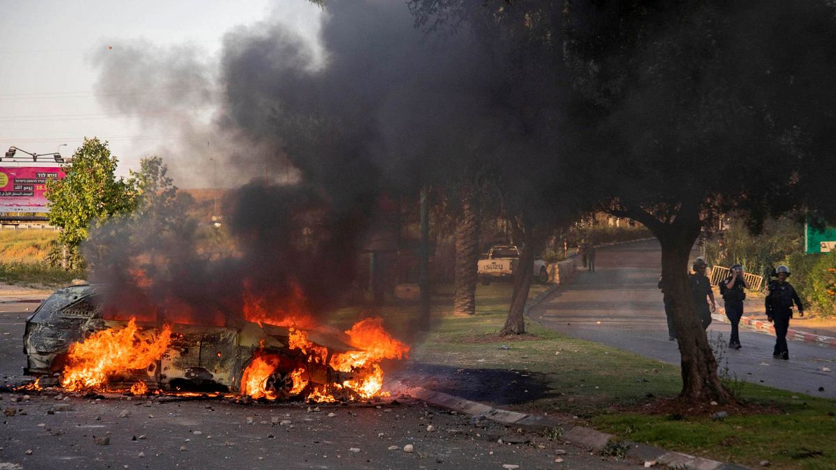 سيارة شرطة إسرائيلية تحترق بعد مظاهرة قام بها عرب إسرائيل في أعقاب جنازة موسى حسونة في وسط مدينة اللد بالقرب من تل أبيب، 11 مايو 2021