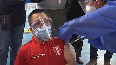 Joven con síndrome de Down recibiendo la vacuna en Lima (Perú)
