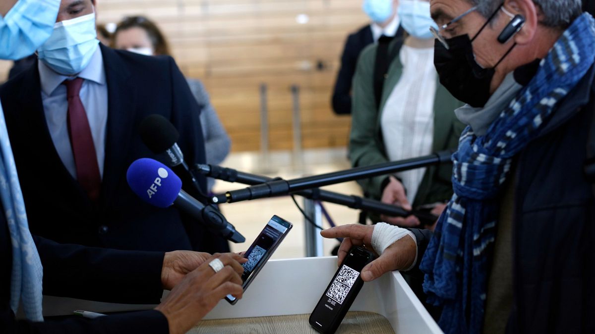 A passenger shows his mobile phone with an uploaded antigen and PCR test prior to board at the Paris-Orly airport, in Orly, south of Paris,  April 27, 2021.
