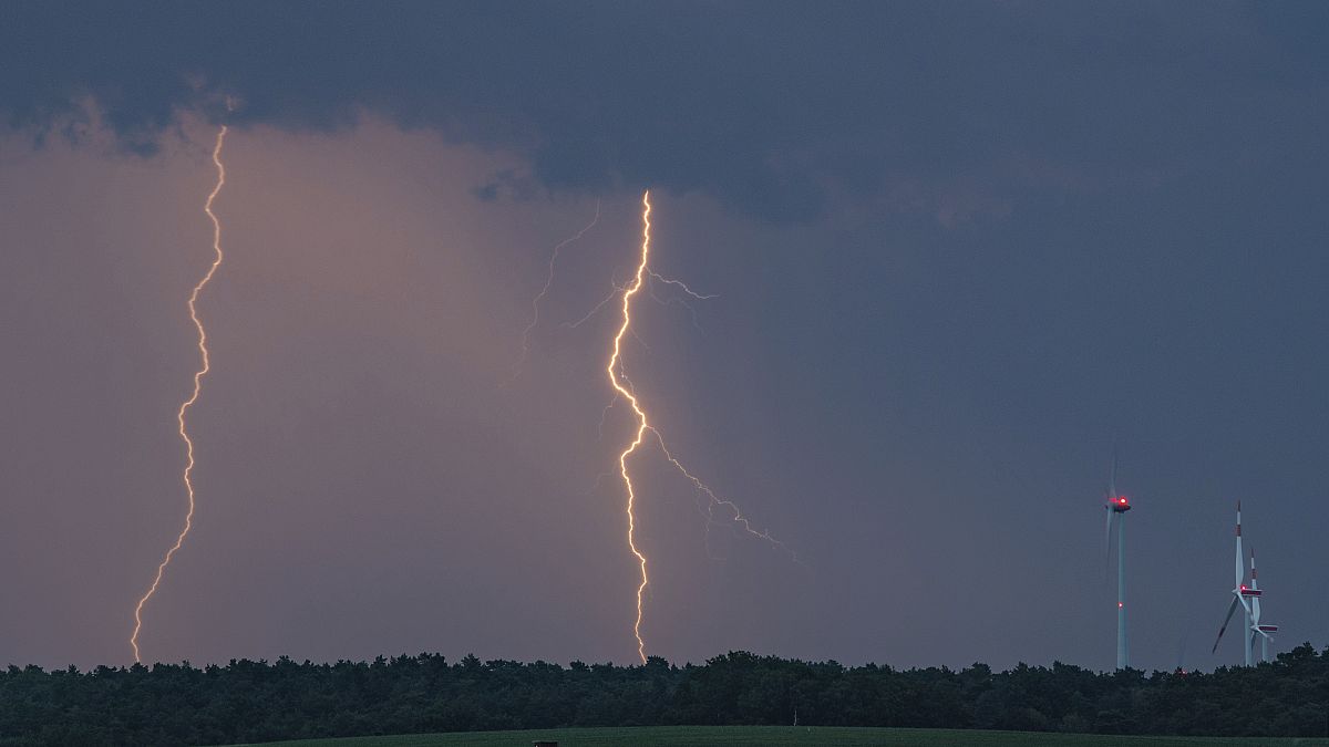 Lightning strikes over a field near wind turbines in Treplin, Germany, June 12, 2019.