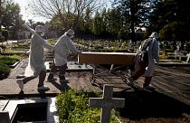 Cemetery workers push the coffin of a COVID-19 victim at a cemetery in Buenos Aires, Argentina, May 8, 2021.