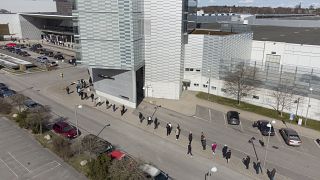 People queue to receive a dose of a COVID-19 vaccine, outside the Stockholmsmassan exhibition centre in Stockholm.