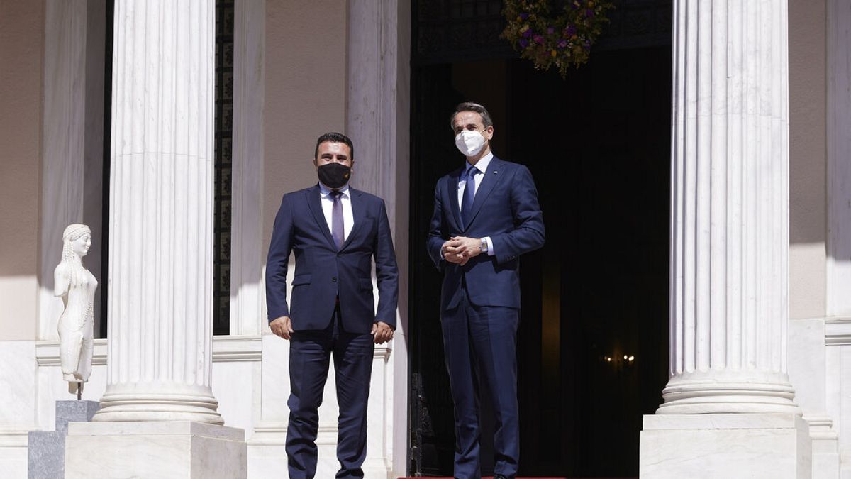 Greek Prime Minister Kyriakos Mitsotakis, right, and his North Macedonian counterpart Goran Zaev stand at the entrance of Maximos Mansion