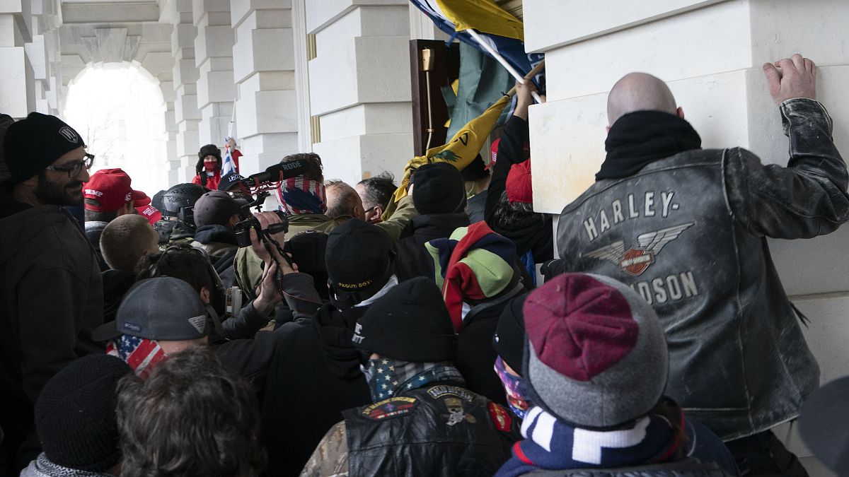 صورة من الارشيف- يحاول المتمردون الموالون لدونالد ترامب فتح باب مبنى الكابيتول الأمريكي 