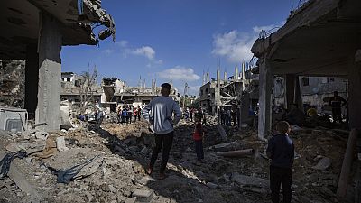 Palestinians inspect their destroyed houses following overnight Israeli airstrikes